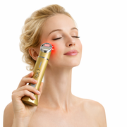 Woman using Platinum Deluxe red light therapy device on face for anti-aging skincare treatment at home